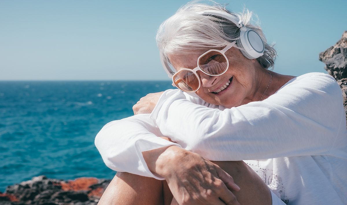 senior lady enjoying the beach outside of the senior care facility after positive medical healthcare website experience